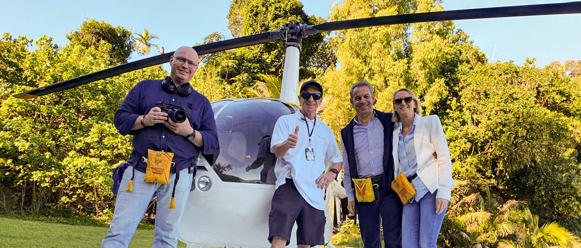 Production crew beside a helicopter