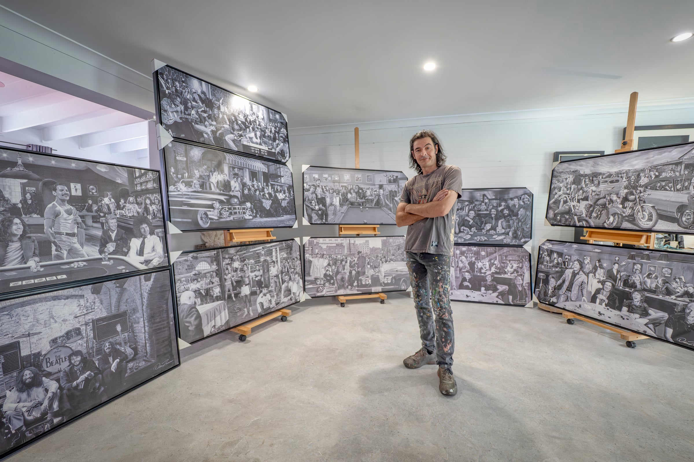 Dean Turner standing among a gallery of his detailed music artworks