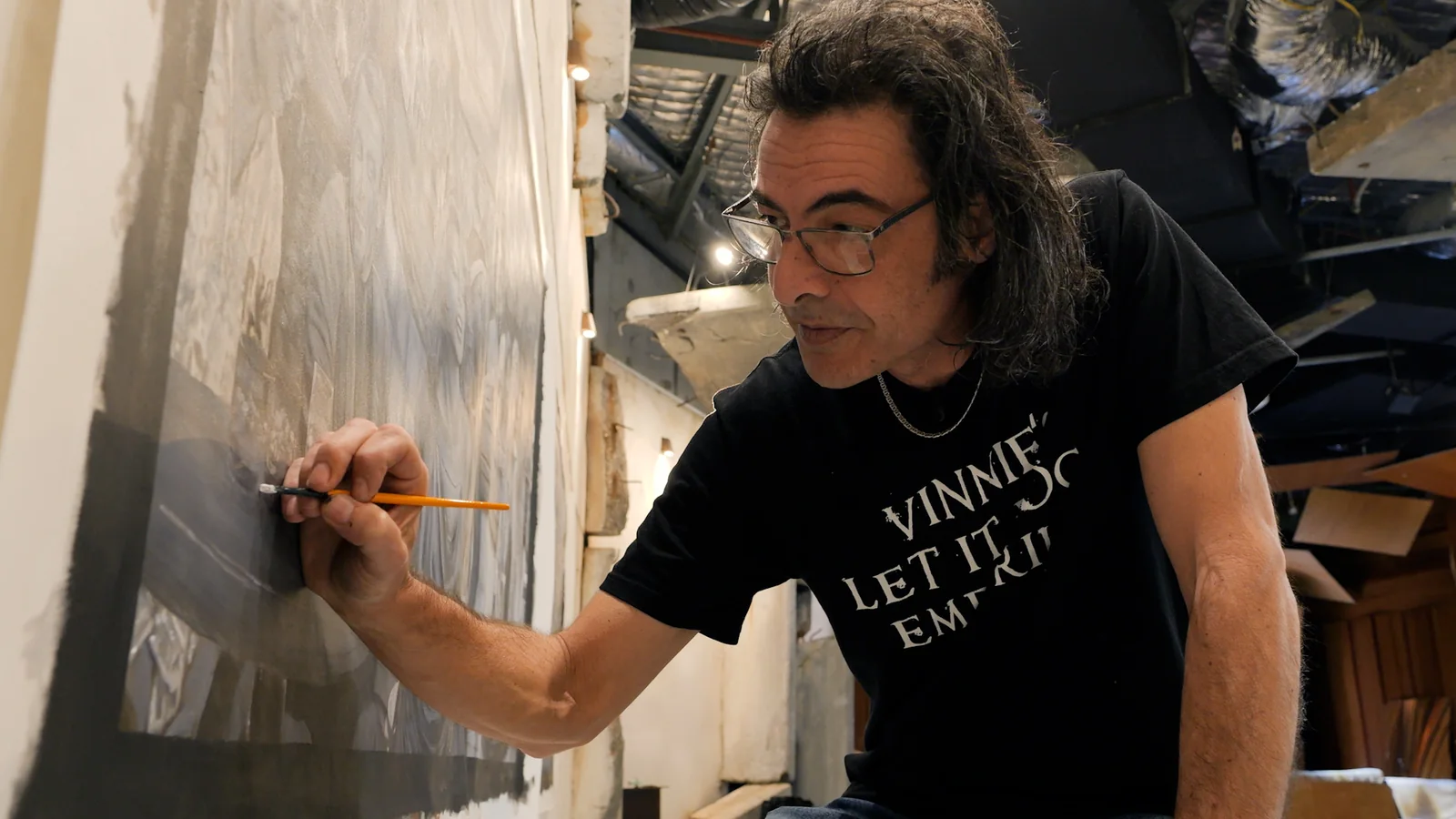 Dean Turner carefully painting fine detail into his Aussie Pub artwork