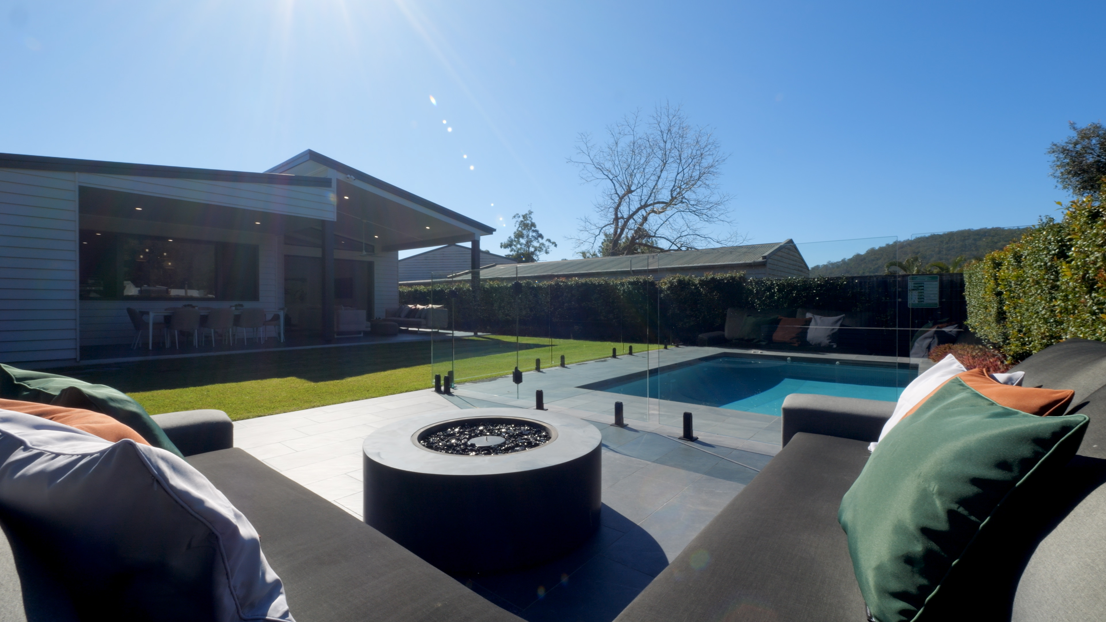 Original daytime video frame of the pool and outdoor fireplace