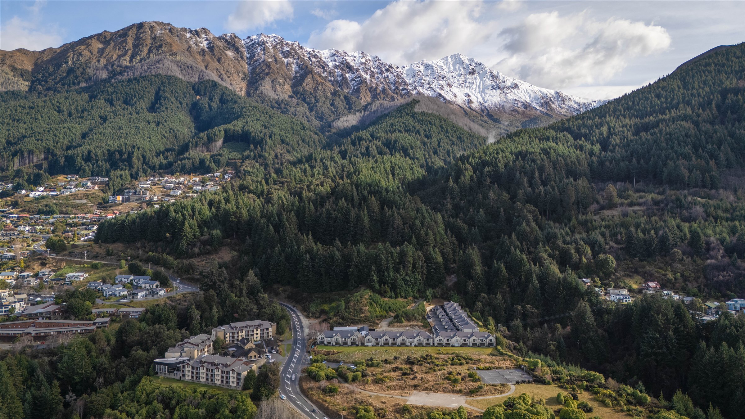 Aerial view of Platinum Luxury Villas beneath the snow-capped Queenstown mountains