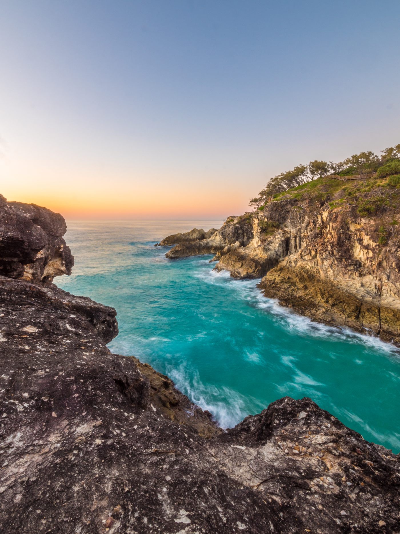 Turquoise water and rocky Queensland coastline at dawn