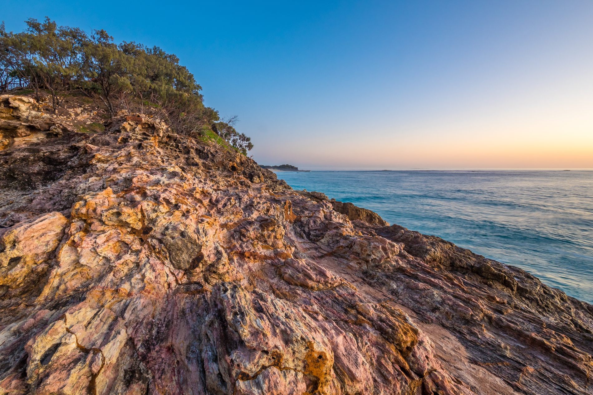 Rocky Queensland headland beside calm blue water