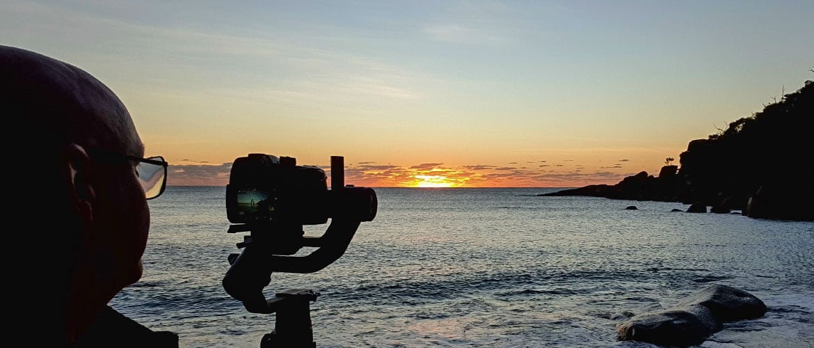 Camera filming a coastal sunrise